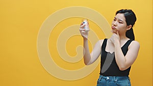 Young asian woman holding jar with savings and thinking