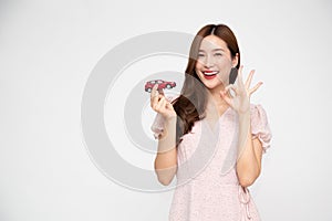Young Asian woman holding red car model and showing ok sign  on white background.