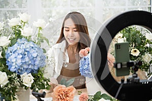 Young Asian woman in home make an online presenting and live broadcast for sale her flowers delivery online.