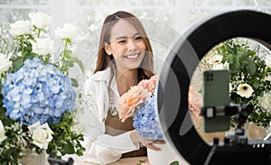 Young Asian woman in home make an online presenting and live broadcast for sale her flowers delivery online.