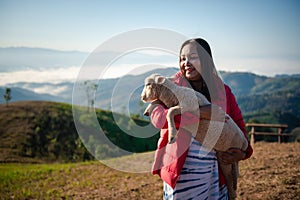 Young Asian woman is hugging intimately a little lamb at sheep farm in the morning