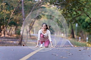 Young Asian woman jogging in the morning at a public park on a bright sunny day