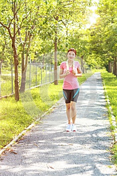 Young asian woman jogging during Outdoor Workout in a Park.