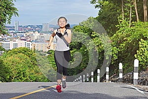 Young asian woman jogging in park smiling happy running