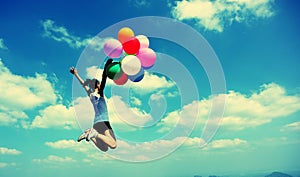 Young asian woman jumping with colored balloons