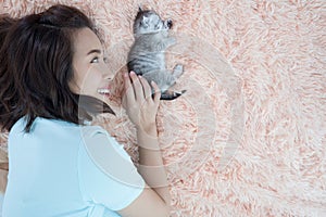 Young Asian woman with kitten cat pet sleep on the bed.