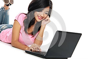 Young asian woman with a laptop , laying on the floor isolated