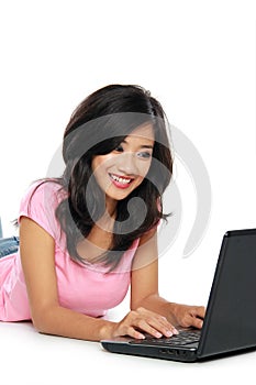 Young asian woman with a laptop , laying on the floor isolated