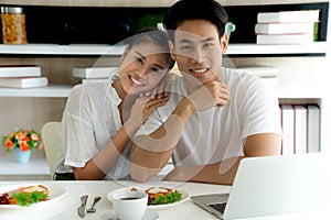 Young asian woman leaning on shoulder of handsome man. Portrait of husband and wife look at camera and smile.