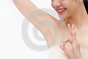 Young Asian woman lifting hands up to show off clean and hygienic armpits or underarms and giving okay sign photo