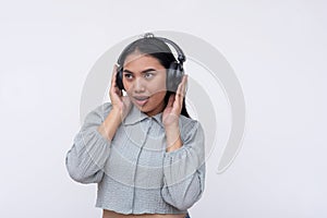 A young asian woman listening to great music on her wireless headphones. Isolated on a white background