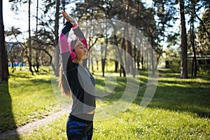 Young asian woman listening to music in the forest. Woman listening to music during workout.