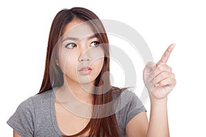 Young Asian woman look and point to copy space
