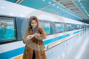 Young asian woman looking her watch while checking time for the train