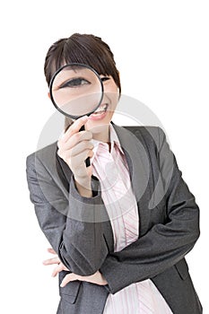 Young asian woman looking through a magnifying glass