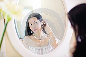 Young Asian woman looking in the mirror