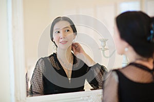 Young Asian woman looking in the mirror