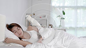 Young Asian woman lying on bed woke up and greeted by a cockatoo parrot in the morning photo