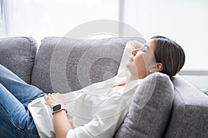 Young asian woman lying relaxing on couch in living room. She take nap or daydream, Close-up photo