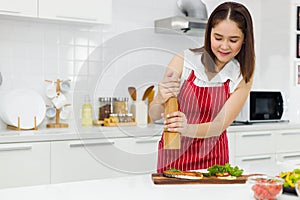 Young Asian woman is making salmon steak fish deliberately