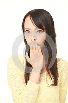 Young Asian woman making the speak no evil gesture