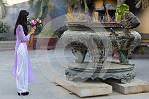 Young Asian woman making a votive offering