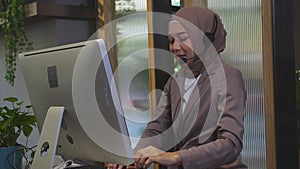 Young asian woman is muslim wearing headset working call center at office, assistant is islam using computer online.