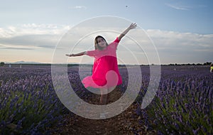 Young Asian woman outdoors at lavender flowers field - happy and beautiful Chinese girl in sweet Summer magenta dress enjoying