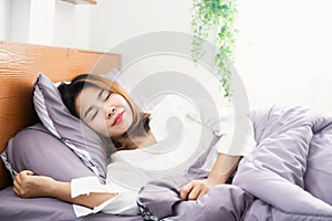 Young Asian woman peacefully  sleeping well on comfortable soft bed