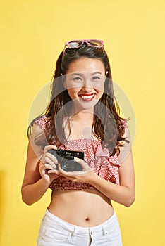 A young Asian woman photographer holding film camera