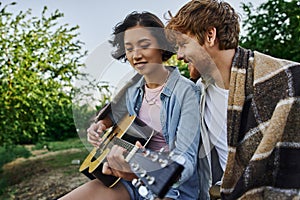 young asian woman playing acoustic guitar