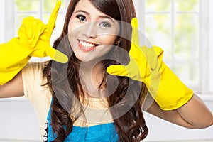 Young asian woman playing around with a yellow latex gloves on
