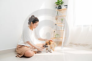 Young Asian woman playing with her dog at home