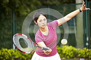 Young asian woman playing tennis
