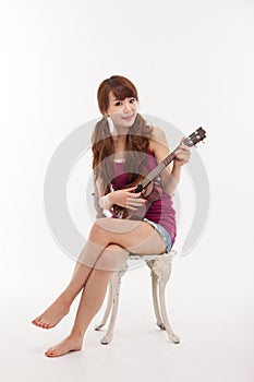 Young Asian woman playing ukulele.