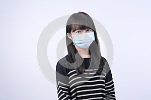 Young Asian woman portrait, wearing a medical surgical blue face mask for epidemic prevention, air pollution isolated on white