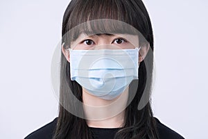 Young Asian woman portrait, wearing a medical surgical blue face mask for epidemic prevention, air pollution isolated on white