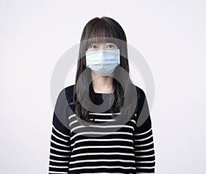 Young Asian woman portrait, wearing a medical surgical blue face mask to prevent infection sick, air pollution isolated on white