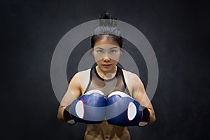 Young Asian woman posing with boxing gloves