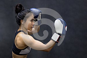 Young Asian woman posing with boxing gloves