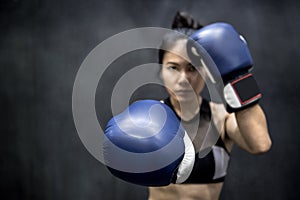 Young Asian woman posing with boxing gloves