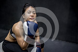 Young Asian woman posing with boxing gloves