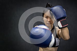 Young Asian woman posing with boxing gloves