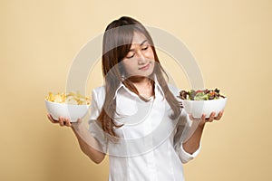 Young Asian woman with potato chips and salad