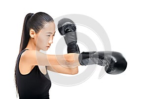 Young Asian woman in profile in black boxing gloves strikes