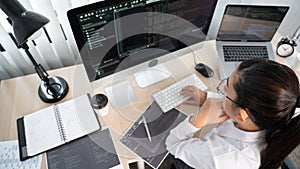 Young Asian woman Programmer Typing code working with computer at table, coding cyberspace and Web Development Concept