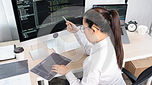 Young Asian woman Programmer Typing code working with computer at table, coding cyberspace and Web Development Concept