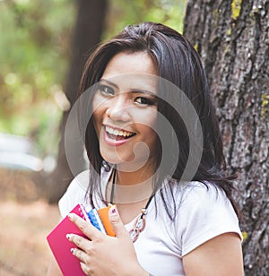 Young asian woman reading a book outdoor in a park