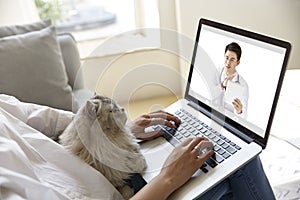 Young asian woman receiving an online diagnosis using tele-medicine network