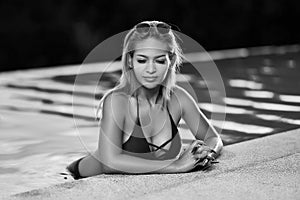 Young asian woman in red swimsuit posing at swimming pool